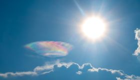 Beautiful Iridescent clouds appear on the sky nearly the sun.