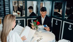 Young man and woman read the menu in a fancy restaurant.