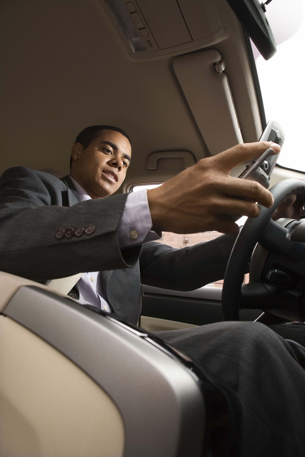 Businessman using cell phone while driving