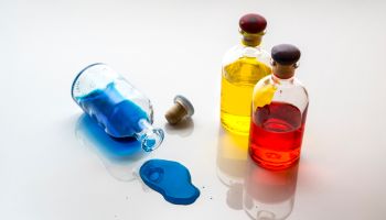 High Angle View Of Colorful Liquids In Bottles On White Background