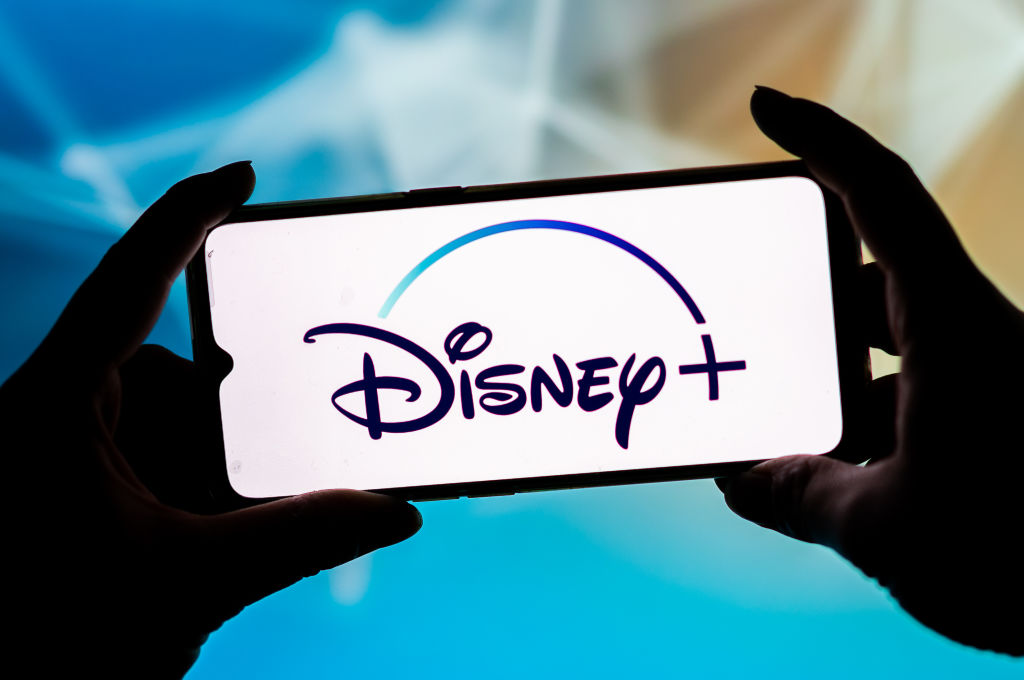 In this photo illustration a Disney Plus logo seen displayed...