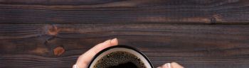 Directly Above Shot Of Woman Hands Holding Black Coffee In Cup On Table