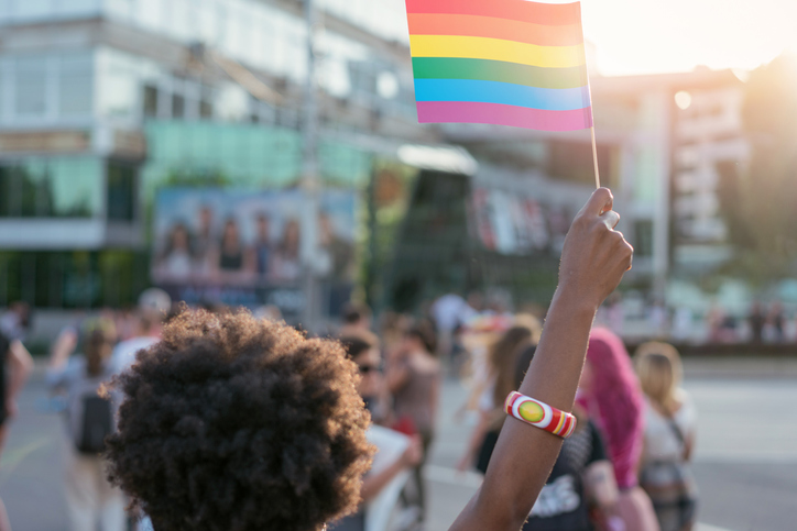 Young African ethnicity woman waving rainbow pride flag at the love festival