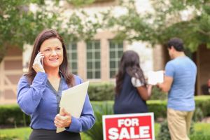 Real estate agent and young couple buying a home.