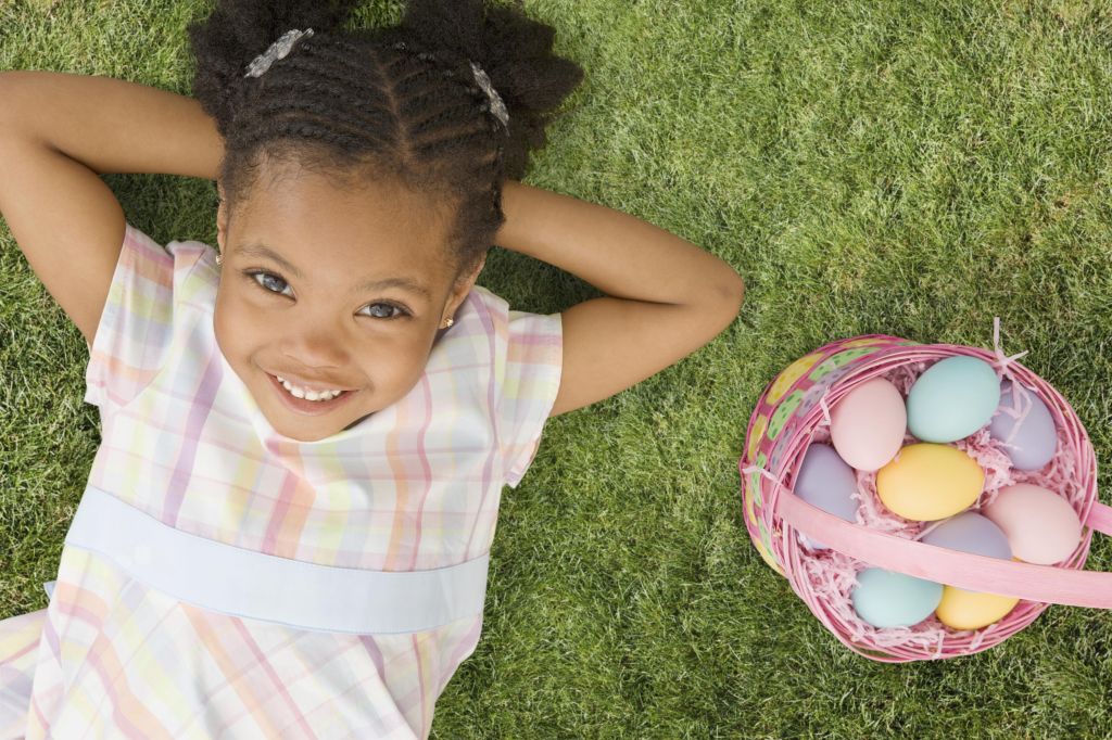 African girl laying next to Easter basket
