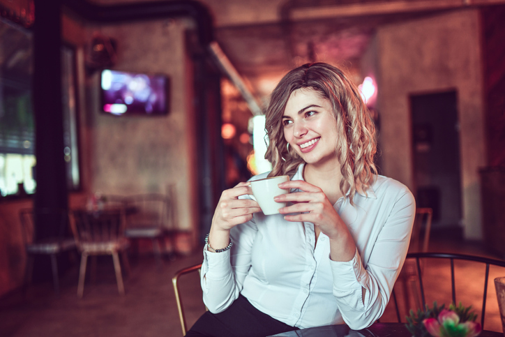 Smiling Female Beauty Enjoying Cup Of Good Coffee While Relaxing In Bar