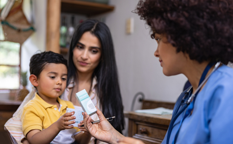 Doctor giving prescription medicine to a boy while making a house call