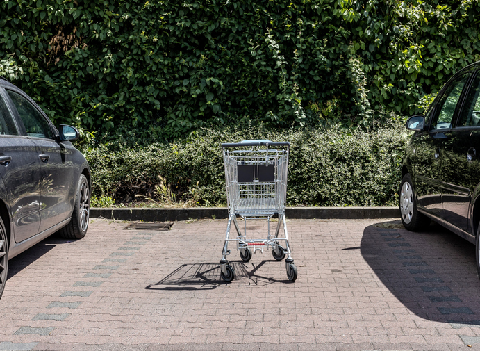Shopping cart, parked between two cars