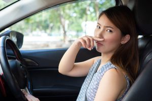 Young woman holding her nose because of bad smell in car