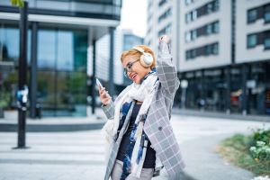 Young woman listening a music over headphones in city