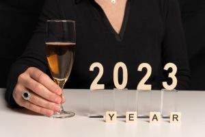 Paris, France - 12 31 2022: A woman wishes you a New year 2023 with a glass of champagne