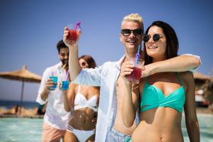 Group of friends having fun at summer party and drinking cocktail