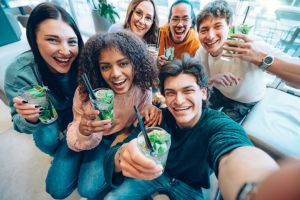 Multiracial friends drinking mojito cocktails at bar restaurant - Happy young people taking selfie picture hanging out on weekend vacation - Life style concept with guys and girls enjoying happy hour