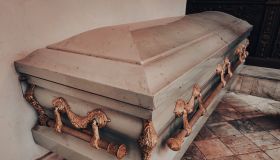 close up shot of a metal casket with gold ornaments in a chapel or funeral home