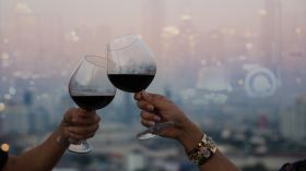 Hand of romantic couple or friendship which happy moment relaxing ,red,wineglass,celebration on the rooftop in the night with bokeh background