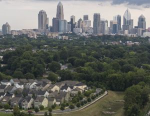 Residential houses with the distant view of Downtown Charlotte, North Carolina, USA, against the stormy sky in the evening. Stitched vertical panorama.