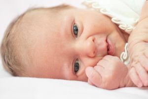 Cute newborn baby lying down looking at the camera. Sweet new born baby.