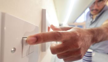 man switching on electric light