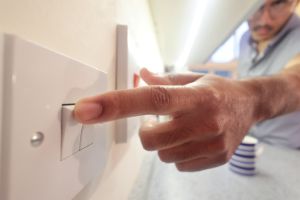 man switching on electric light