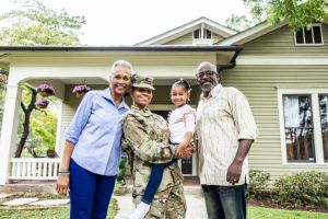 Portrait of female U.S. soldier and multi-generational family in front of home