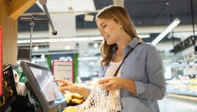 Woman using self service checkout