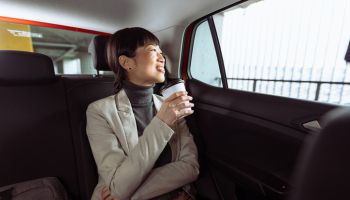 A mid adult Japanese woman enjoying a car ride