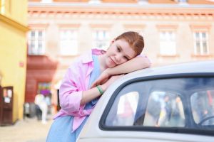 girl in a summer dress leaned against a white retro car