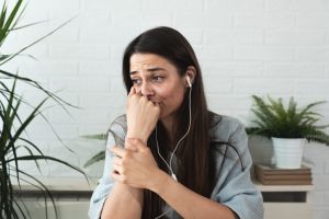Young stressed and depressed woman talking on video call with her psychotherapist on online therapy from her home open her hart and confess everything that make her sad and miserable