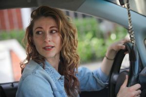woman driving car and looking over her shoulder backing up