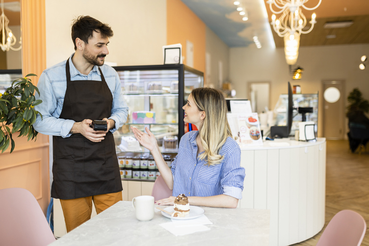 Shot of a young woman making a card payment using a nfc machine