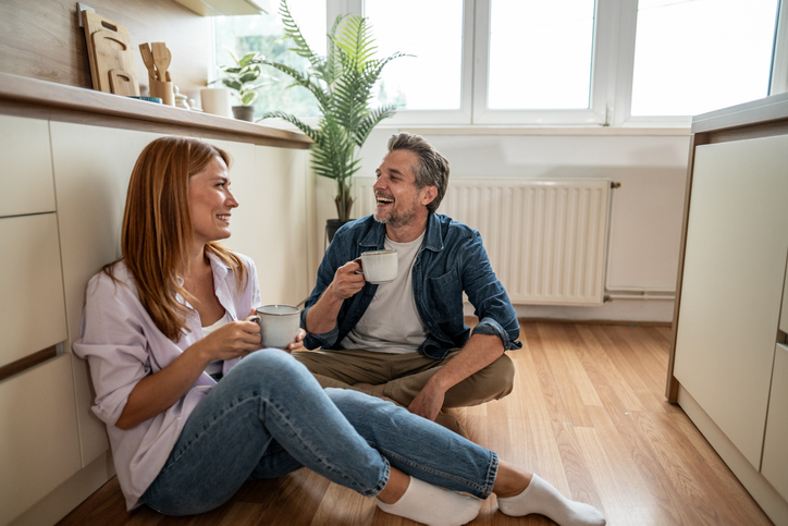 Happy couple enjoying coffee together in their modern kitchen